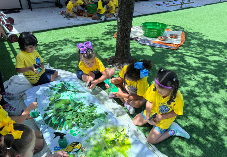 Children enjoying a hands on art and painting activity outdoors at Pines West Academy